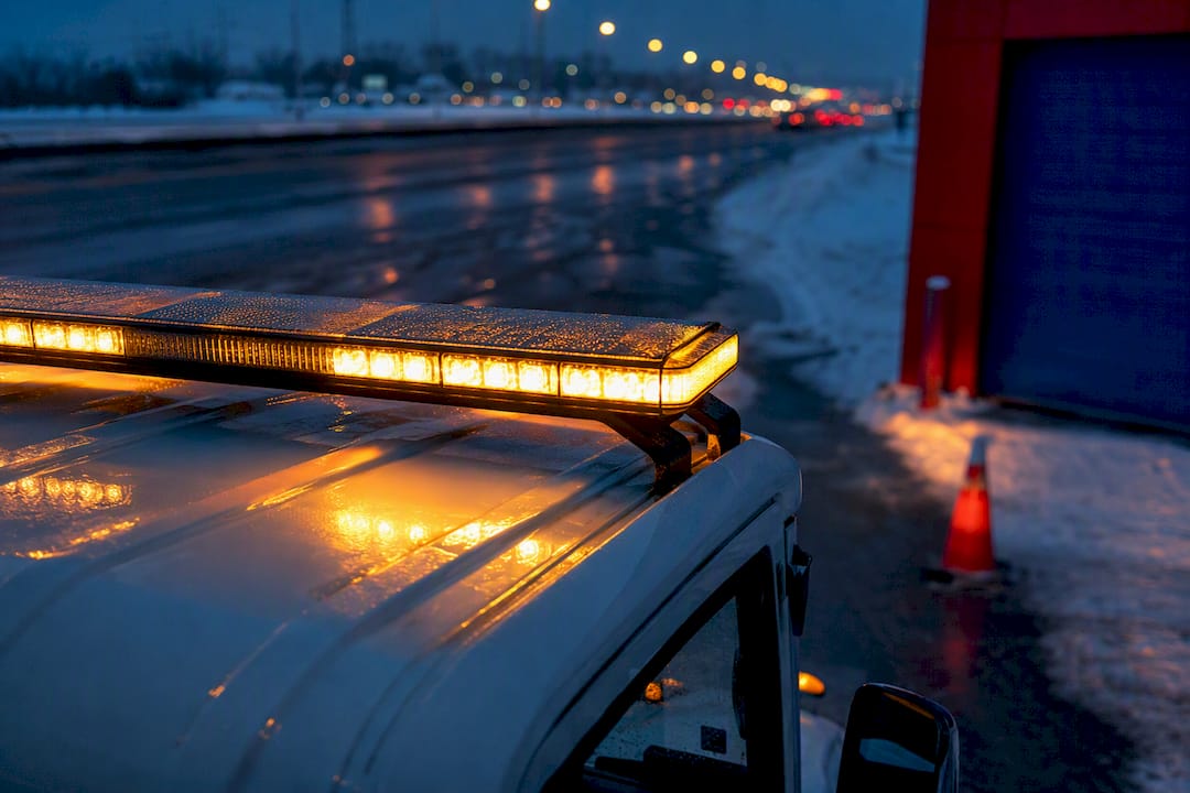 Tow truck lightbar on winter highway shoulder