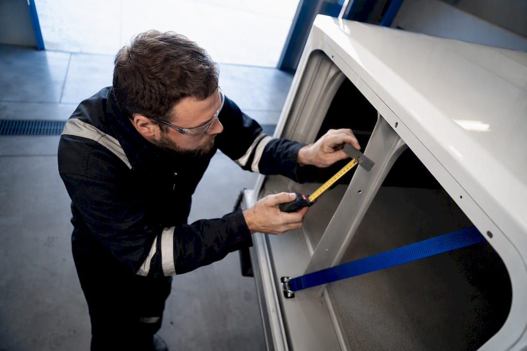 Technician measuring anonymous fleet cargo clearance