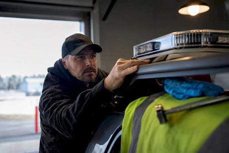 Tow operator inspecting warning lamp housing