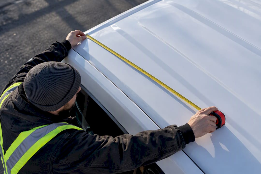 Technician measuring usable vehicle roof flat