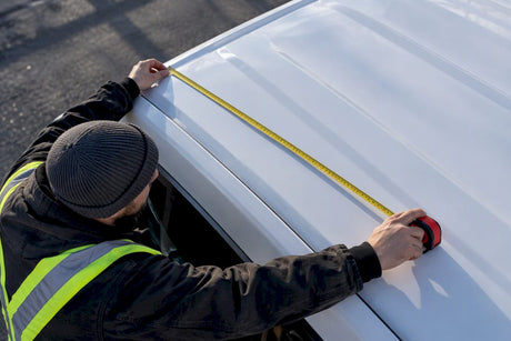 Technician measuring usable vehicle roof flat