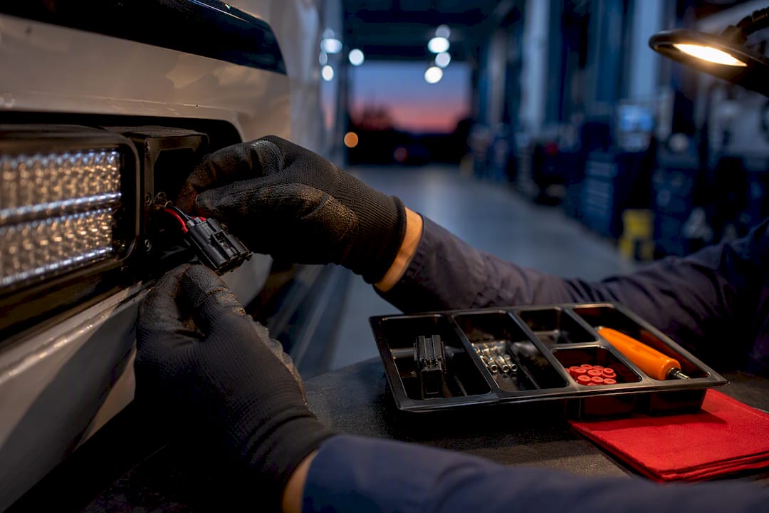 Technician swapping a fleet lighting harness